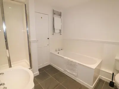 a bathroom with a tub and a toilet and a sink at Weir Cottage in Ambleside