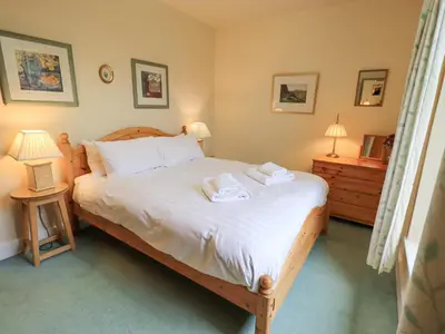 a bedroom with a bed with two towels on it at Holme Ground Cottage in Coniston