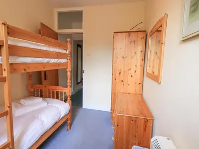 a bedroom with two bunk beds and a closet at Holme Ground Cottage in Coniston