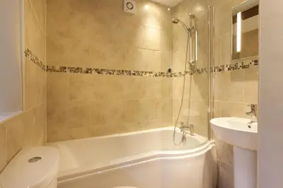 a bathroom with a tub and a toilet and a sink at Wythebank in Ambleside