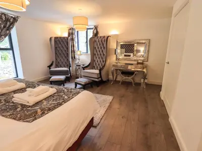 a hotel room with two beds and a desk at Le Chalet in Elterwater