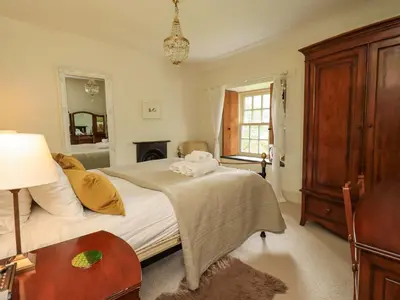 a bedroom with a bed and a table and a mirror at Beck Steps in Chapel Stile