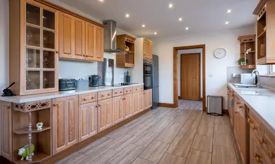 a large kitchen with wooden cabinets and wooden floors at Sherriff in Penrith