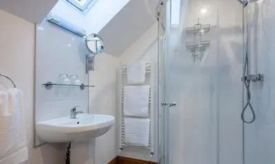 a white bathroom with a sink and a shower at Sherriff in Penrith
