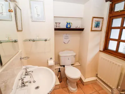 a bathroom with a toilet and a sink at Gunpowder Cottage in Elterwater