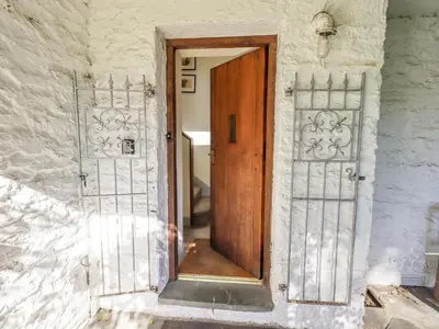 an open wooden door in a white building at Croft in Grasmere