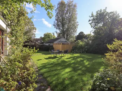 a garden with a table and chairs on the grass at Croft in Grasmere