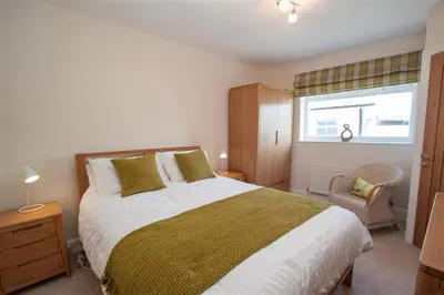 a bedroom with a large bed and a window at Gable End in Keswick