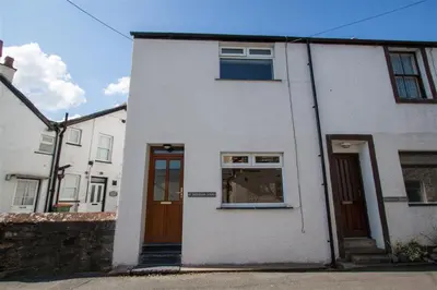 a white house with two doors and a window at Gable End in Keswick