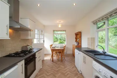 a kitchen with a sink and a table in it at The Haven in Keswick