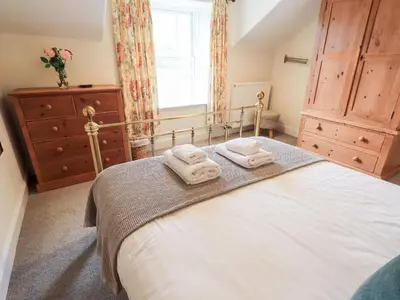a bedroom with a bed with two towels on it at Holmdale in Ambleside