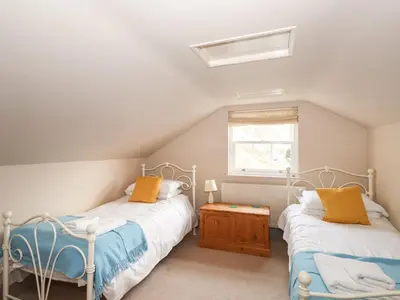 two beds in a attic bedroom with a window at Underfell in Ambleside
