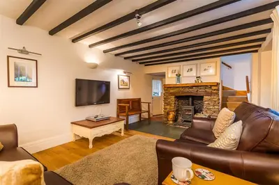 a living room with a couch and a fireplace at Dove Holme Cottage in Grasmere