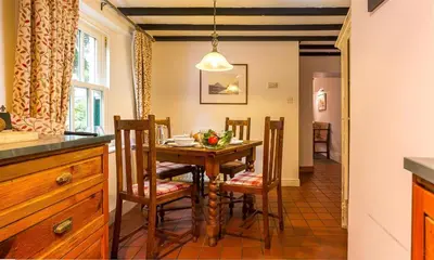 a kitchen and dining room with a table and chairs at Dove Holme Cottage in Grasmere