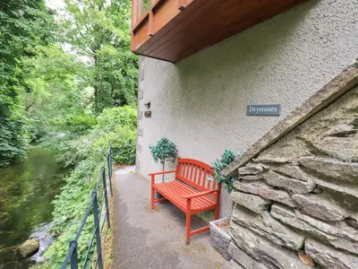 a red bench sitting on the side of a building at Drystones in Grasmere