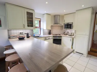 a kitchen with a wooden table and chairs in it at Drystones in Grasmere