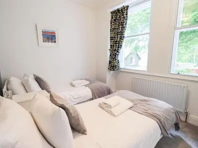 two twin beds in a room with a window at Drystones in Grasmere