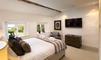 a bedroom with a large bed and a tv on the wall at Underhowe in Grasmere