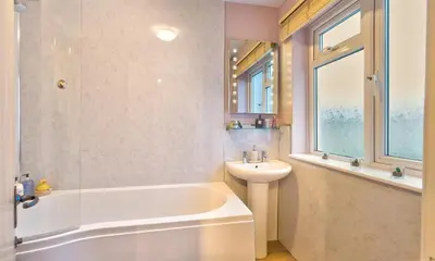 a bathroom with a white tub and a sink at The Cats Bield in Keswick