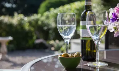 two wine glasses and a bottle on a table at Scots Pine in Keswick