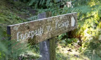 a stone sign for a forested hiking trail at Scots Pine in Keswick