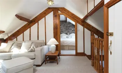 a living room with a white couch and a bed at High Raise in Grasmere