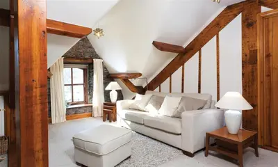 a living room with a white couch and a staircase at High Raise in Grasmere