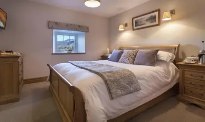 a bedroom with a large bed and a window at Cedar Nook in Loweswater