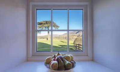 a bowl of fruit sitting in front of a window at Cedar Nook in Loweswater