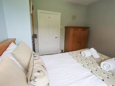 a bedroom with a bed with two towels on it at The Smithy in Borrowdale Valley