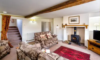 a living room with a couch and a fireplace at Low Longthwaite Farm in Watermillock