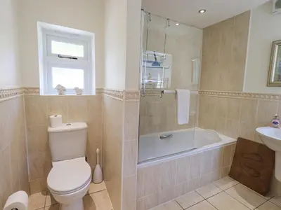a bathroom with a toilet and a tub and a sink at Rowan Cottage in Grasmere