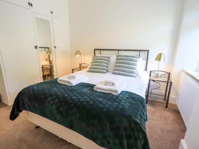 a bedroom with a large bed with towels on it at Rowan Cottage in Grasmere