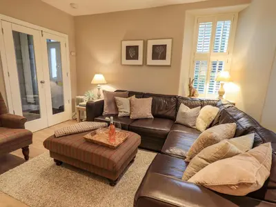a living room with a brown leather couch at Honeywood House in Grasmere