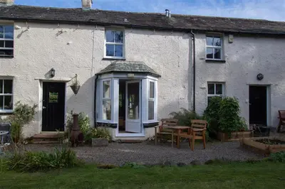 a white house with a table in front of it at Swinside Cottage in Keswick