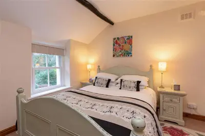 a bedroom with a bed with two pillows and a window at Swinside Cottage in Keswick