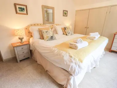 a bedroom with a large bed with towels on it at Rawfell in Ambleside
