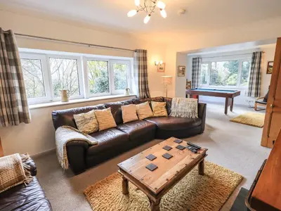 a living room with a leather couch and a table at Rawfell in Ambleside