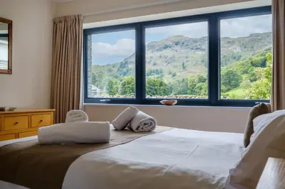 a bedroom with a bed and a large window at The Old Police House in Grasmere