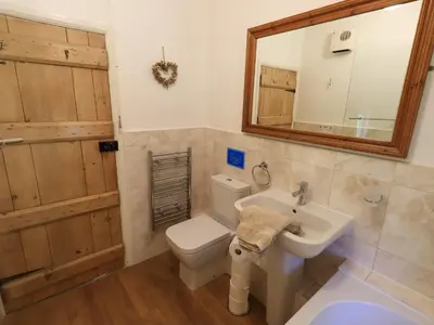 a bathroom with a toilet and a sink and a mirror at Bleaberry Cottage in Penrith