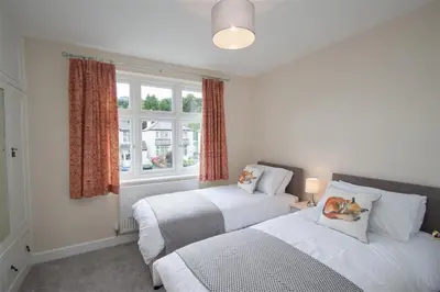 a bedroom with two beds and a window at Fell End in Keswick