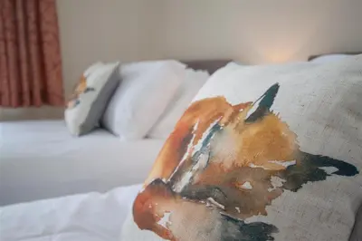 a blanket with a picture of a dog on a bed at Fell End in Keswick