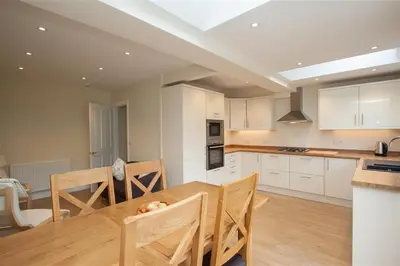 a kitchen with a wooden table and a dining room at Fell End in Keswick