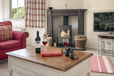 a living room with wine glasses and a fireplace at Wetherlam in Ambleside
