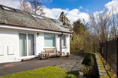 a white house with a bench in front of it at Lingmoor View in Ambleside