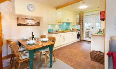 a kitchen with a wooden table and chairs and a dining room at Lingmoor View in Ambleside