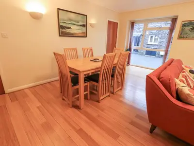 a dining room with a table and chairs and a couch at Molly's Cottage in Grasmere