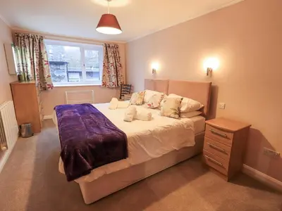 a bedroom with a large bed and a window at Molly's Cottage in Grasmere