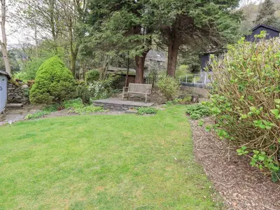 a park with a bench in the middle of a yard at North Lodge in Grasmere