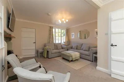 a living room with couches and chairs and a window at Crozier Cottage in Ambleside